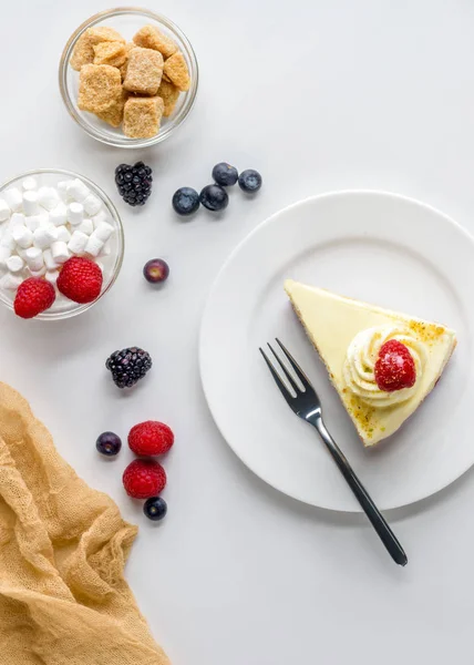 Vue de dessus du morceau de dessert appétissant avec des baies sur la surface blanche — Photo de stock