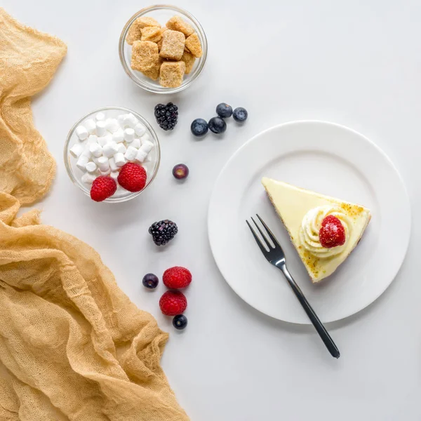 Vista superior del pedazo de delicioso pastel con bayas en la mesa blanca - foto de stock