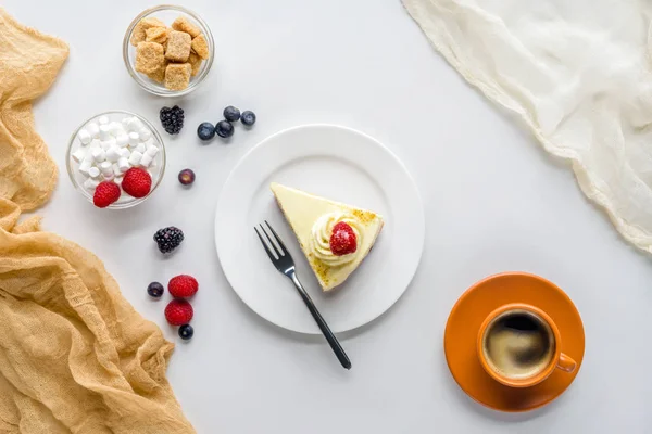 Vue de dessus du morceau de gâteau délicieux avec des baies sur la table blanche — Photo de stock