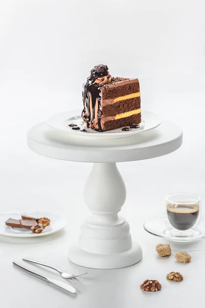 Morceau de gâteau au chocolat sur support de gâteau blanc — Photo de stock