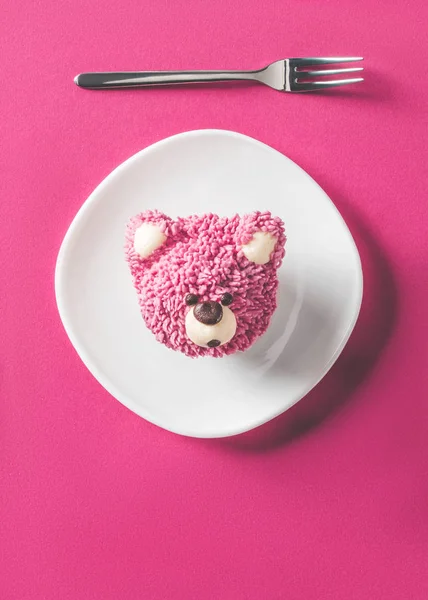Vista dall'alto di cupcake a forma di testa di orso su piatto su superficie rosa — Foto stock