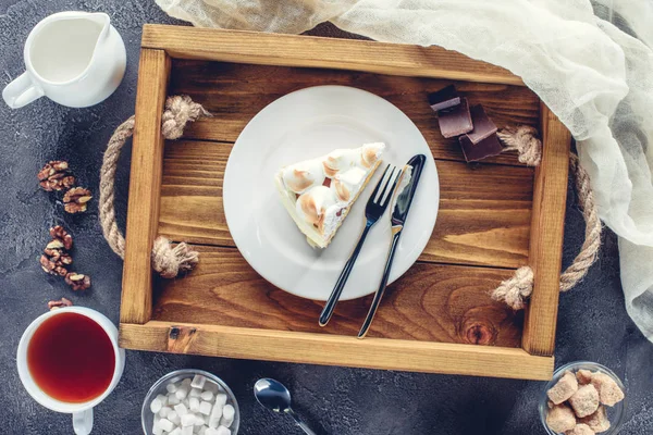 Vista superior de delicioso pedaço de bolo com merengue na placa na bandeja de madeira — Fotografia de Stock