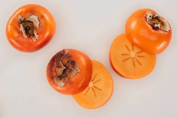 Top view of ripe cut persimmons isolated on white — Stock Photo