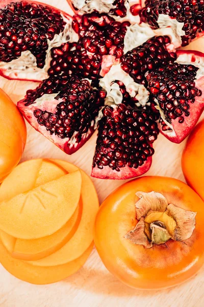 Top view of persimmons and pomegranates on plate — Stock Photo