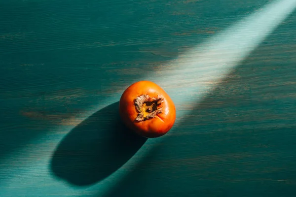 Top view of persimmon on table with light and shadow — Stock Photo