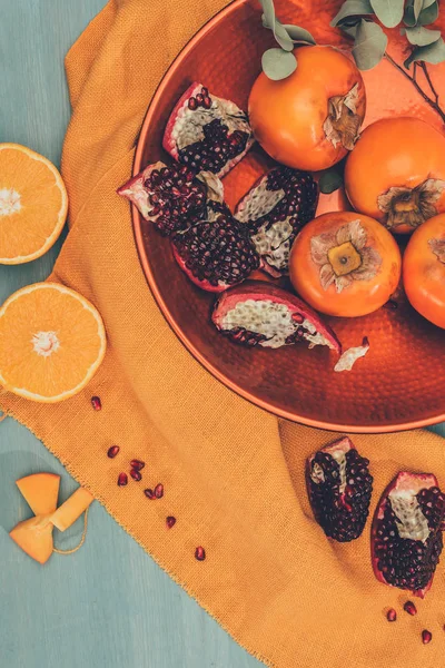 Vista superior de frutas maduras en plato sobre mantel naranja — Stock Photo