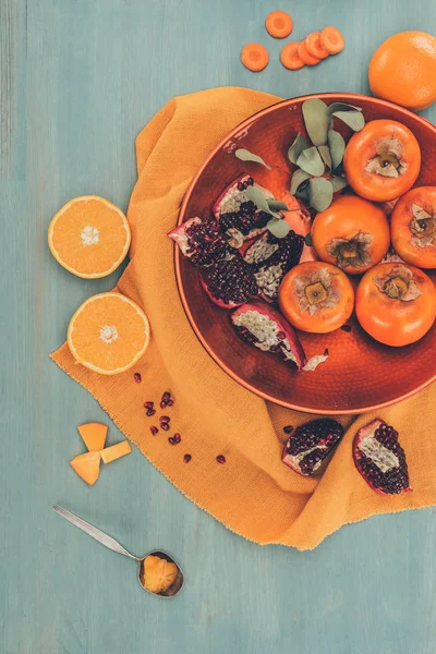 Верхний вид спелых фруктов на тарелке на оранжевой скатерти — стоковое фото