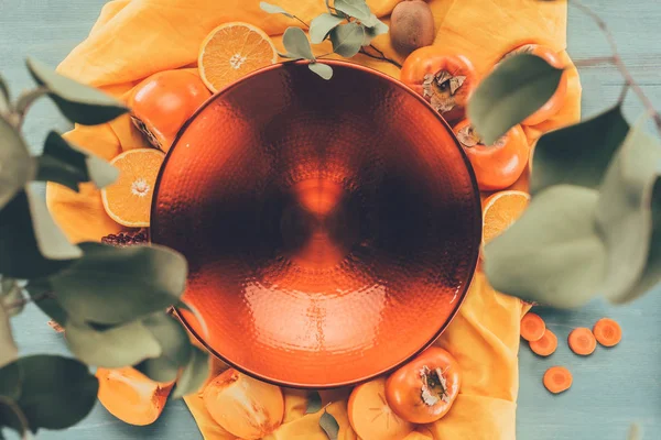 Top view of big red plate on orange tablecloth — Stock Photo