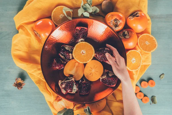 Cropped image of woman taking pomegranate piece — Stock Photo