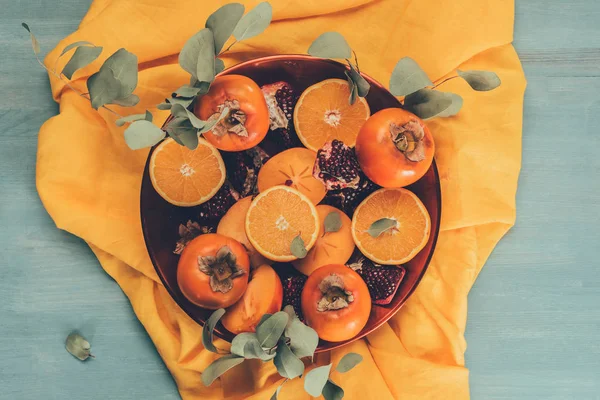 Top view of fruits on plate on orange tablecloth — Stock Photo