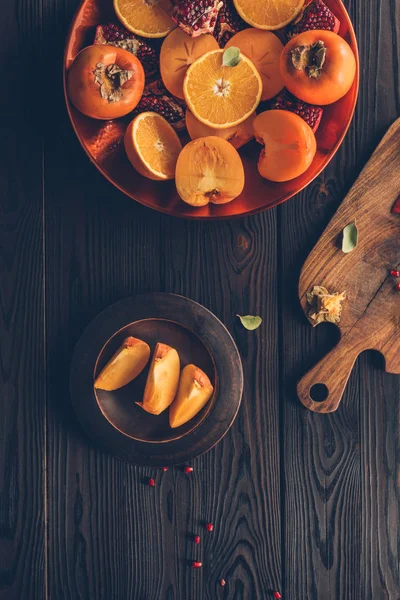 Vista superior de frutas y tablero de madera en la mesa - foto de stock