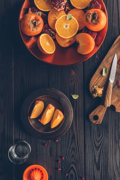 Top view of fruits on plates on wooden table — Stock Photo