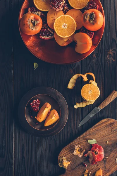 Vista superior de frutas e tábua de corte com faca na mesa — Fotografia de Stock