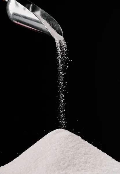 Sugar falling from metal scoop on pile isolated on black — preparation, minimal - Stock Photo | #184854324