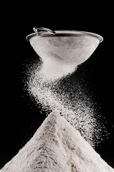 Flour falling after sieving on pile isolated on black — Stock Photo