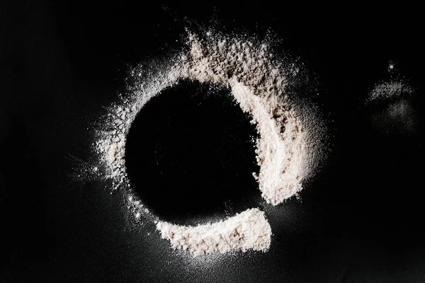 Top view of flour on black tabletop — Stock Photo