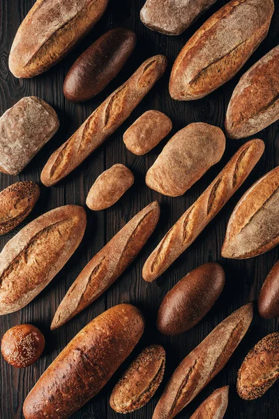 Top view of arranged loafs of bread on wooden surface — Stock Photo