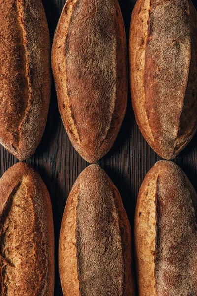 Close up view of arranged loafs of bread on wooden surface — Stock Photo