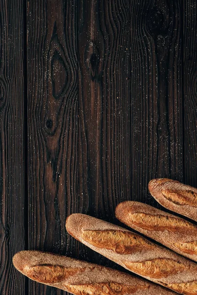 Vista superior de loafs arranjados de baguete francês na superfície de madeira — Fotografia de Stock
