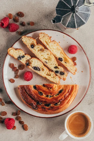 Vista superior de la cafetera, taza de café y pastelería dulce en el plato en la mesa ligera - foto de stock