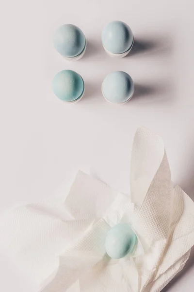 Top view of chicken eggs on stands and on napkin after painting, easter concept — Stock Photo