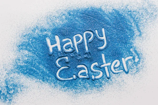 Top view of happy easter sign made of blue sand on white surface — Stock Photo