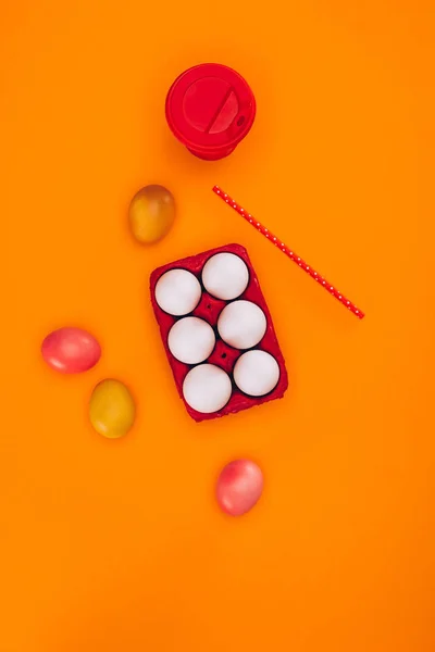 Top view of chicken eggs in red egg tray and coffee isolated on orange — Stock Photo