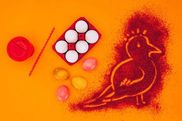 Vista superior de pájaro hecho de arena roja con huevos de pollo aislados en naranja, concepto de Pascua - foto de stock