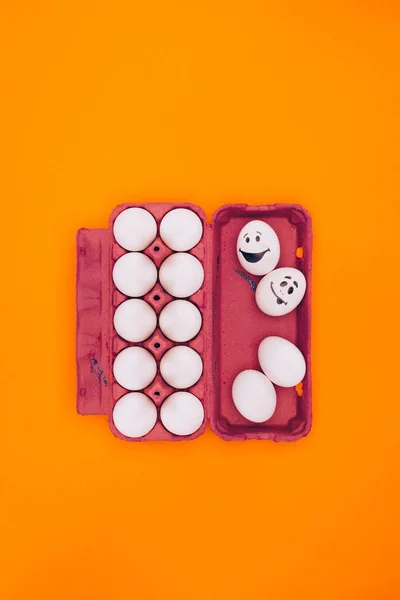 Top view of chicken eggs in egg tray for easter painting isolated on orange — Stock Photo