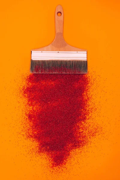 Top view of red sand for decoration and brush isolated on orange — Stock Photo