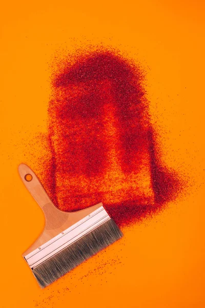 Vista superior de arena roja para decoración y cepillo aislado en naranja - foto de stock