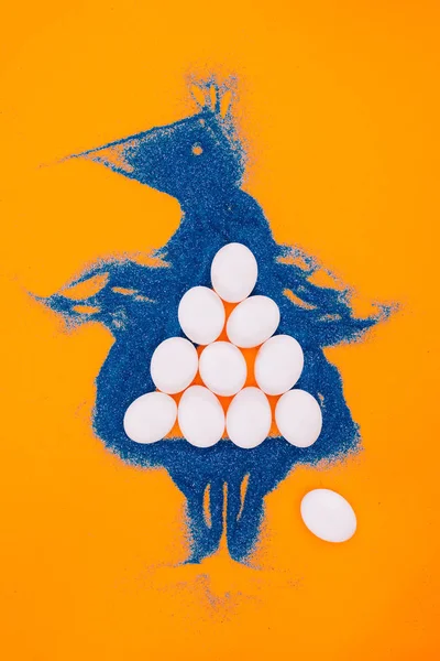 Top view of blue easter chicken made of sand with eggs isolated on orange — Stock Photo