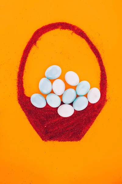 Vista superior de ovos de páscoa em feito de cesta de areia isolada em laranja — Fotografia de Stock