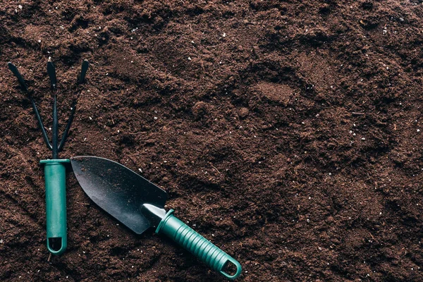 Vista superior de ferramentas jardinando pequenas no solo com espaço de cópia — Fotografia de Stock