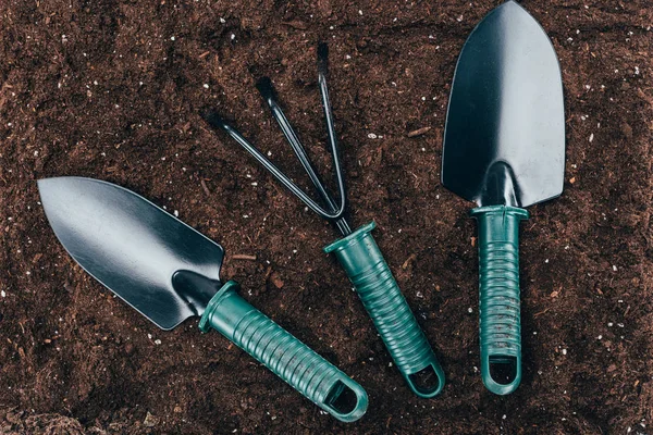 Top view of small gardening tools on soil — Stock Photo