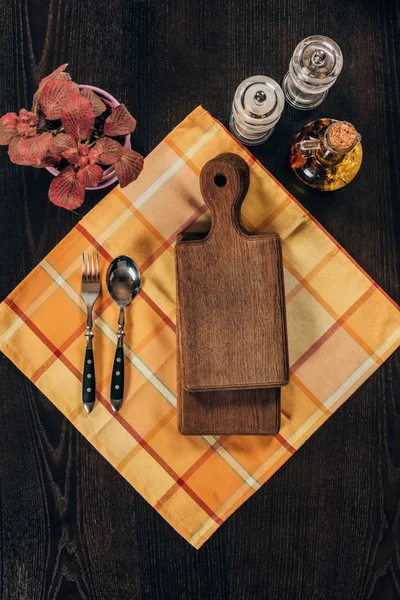 Vista superior de tábuas de madeira com garfo e colher na mesa — Fotografia de Stock