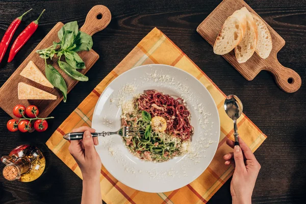 Abgeschnittenes Bild einer Frau, die Pasta mit Speck und Parmesan isst — Stockfoto