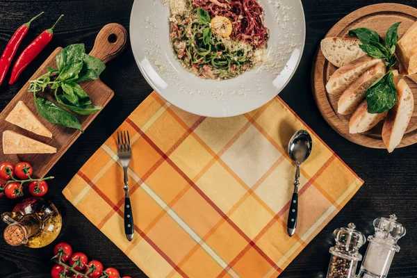 Top view of plate with spaghetti, fork and spoon on table — Stock Photo