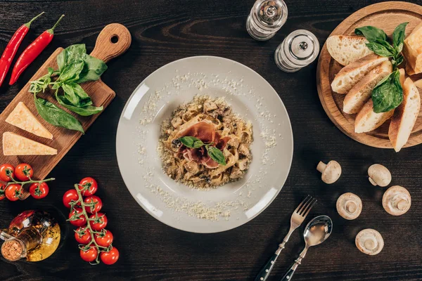 Vue du dessus de la plaque avec des pâtes et de la viande sur une table en bois — Photo de stock