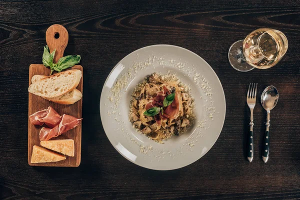 Draufsicht auf Pasta mit Fleisch und Glas Wein auf dem Tisch — Stockfoto