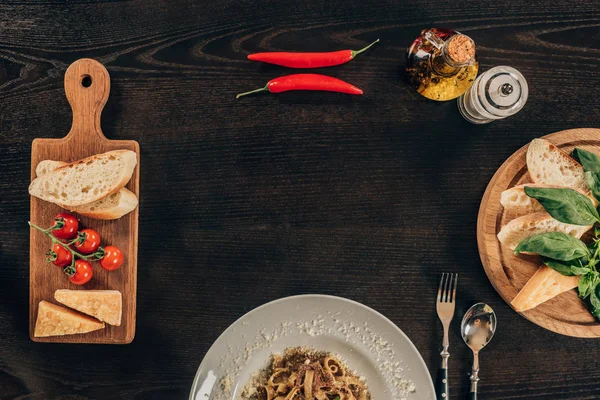 Vista superior de la pasta con carne y chiles sobre mesa oscura - foto de stock