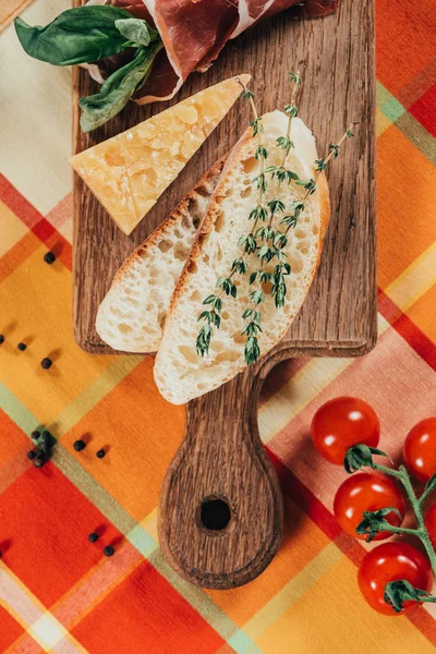 Top view of baguette and parmesan cheese on wooden board — Stock Photo