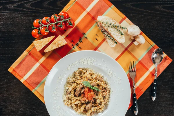 Vue du dessus des pâtes avec du porc rôti sur une assiette sur une serviette de table — Photo de stock