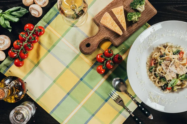 Vista dall'alto di pasta con filetto di persico luccio e vino in tavola — Foto stock