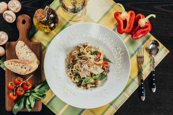 Vue du dessus des pâtes avec filet de sandre et légumes grillés sur la serviette de table — Photo de stock