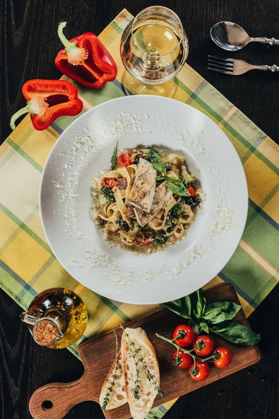 Вид сверху на пасту с филе щуки и жареные овощи на тарелке — стоковое фото