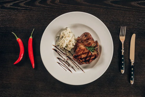 Top view of plate with beef steak and chili peppers on table — Stock Photo