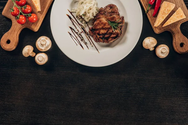 Vue du dessus du steak de bœuf et de l'oignon sur la table noire — Photo de stock