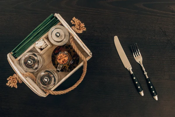 Верхний вид деревянной коробки с оливковым маслом и перцовым шлифовальным станком на деревянном столе — стоковое фото