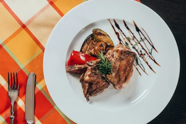 Vista superior de pollo a la parrilla con verduras en el plato en la servilleta de mesa - foto de stock